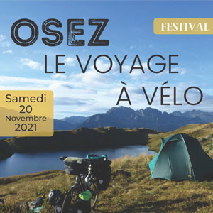 un vélo et une tente installés au bord d'un lac de montagne